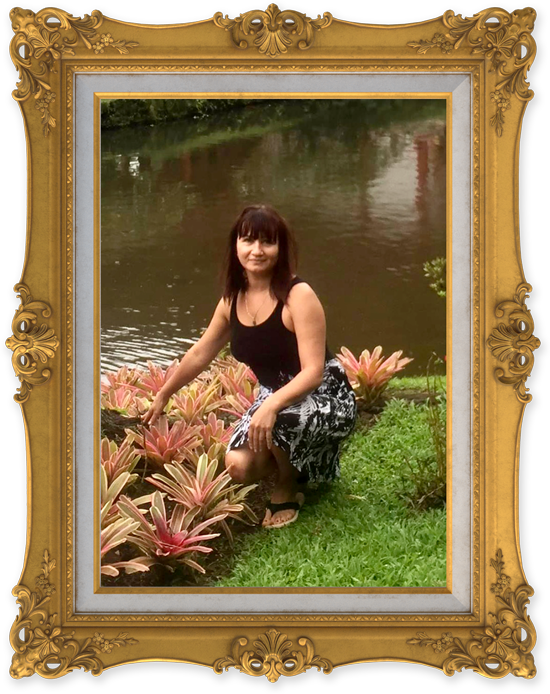 Woman posing for camera kneeling beside pond